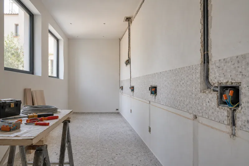Visualización conceptual IA: Canalizaciones y cajas eléctricas durante la preparación de una cocina.